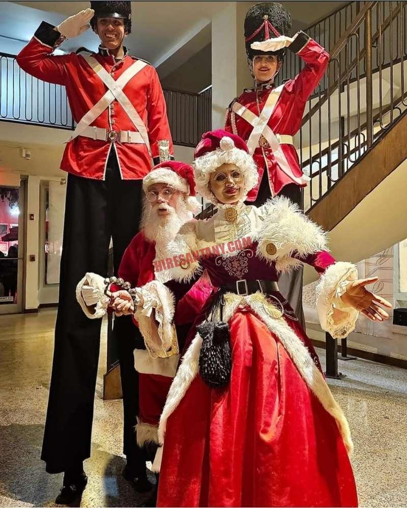Corporate Santa for a New York City office party with nutcracker soldiers and Mrs. Claus indoors