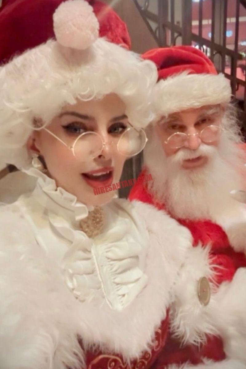 About Hire Santa NY: Santa and Mrs. Claus close-up in holiday costumes, indoor portrait
